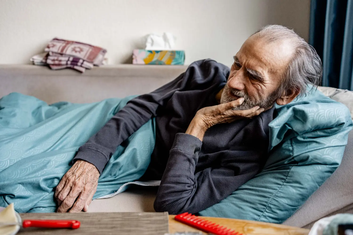 Alter Mann liegt im Bett von Personenbetreuung